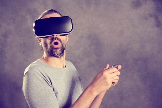 young man with virtual reality glasses looking surprised
