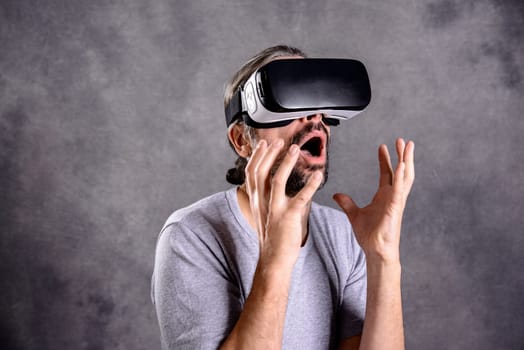 young man with virtual reality glasses looking surprised