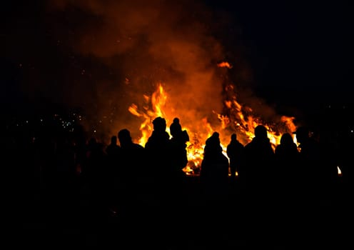 silhouettes of people in frontof big easter fire