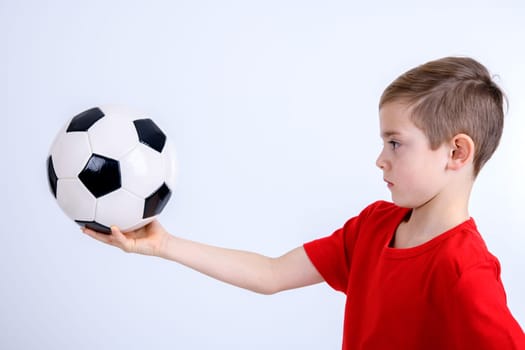 boy in red shirt with soccer ball in front of white background