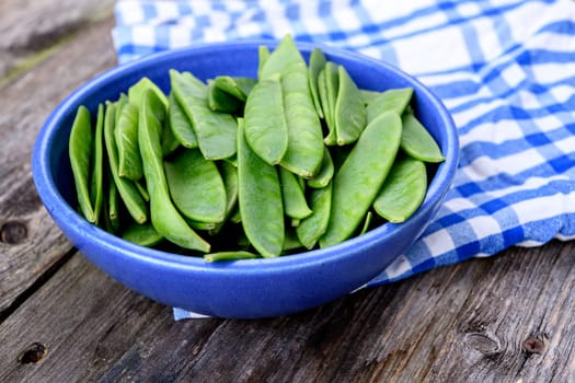 blue bowl with green peapods and towel