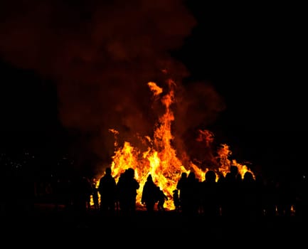 silhouettes of people in frontof big easter fire