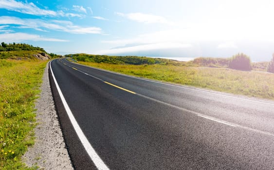 Empty road in Norway, Europe. Auto travel through scandinavia. Blue sky and in background.