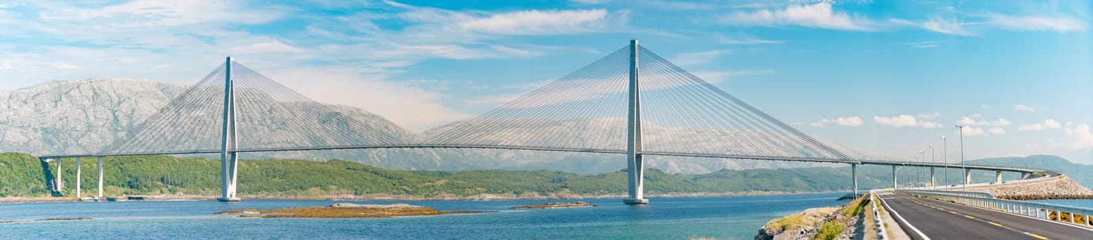 Panorama of bridge and car road in Norway, Europe. Auto travel through scandinavia. Blue cloudy sky, lake and bridge in background.