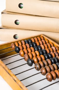 Old abacus and folders with documents, close-up isolated on white