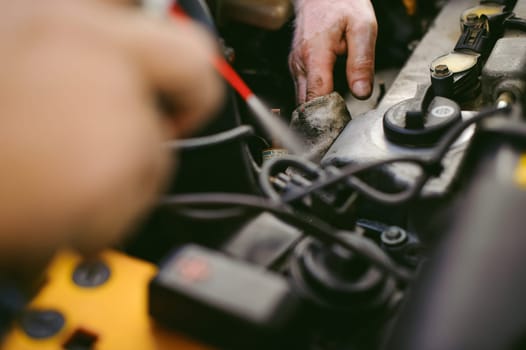hands of an auto mechanic close-up. servicing and caring for a car engine