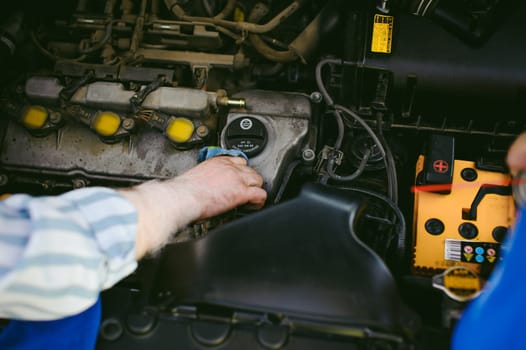 hands of an auto mechanic close-up. servicing and caring for a car engine