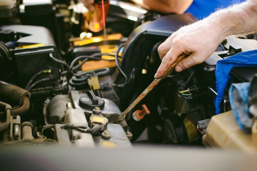 hands of an auto mechanic close-up. servicing and caring for a car engine