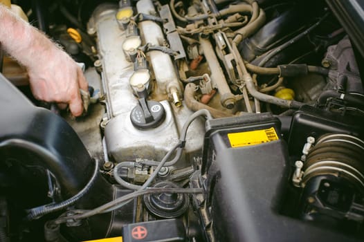 hands of an auto mechanic close-up. servicing and caring for a car engine