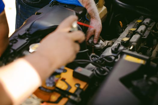 hands of an auto mechanic close-up. servicing and caring for a car engine