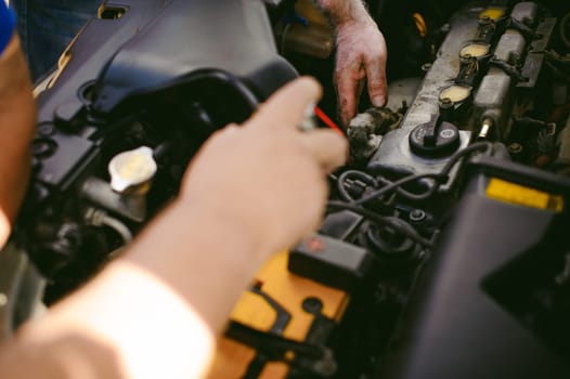 hands of an auto mechanic close-up. servicing and caring for a car engine