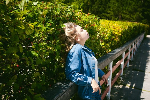 young beautiful woman in jeans clothes outdoors. portrait of a girl with freckles on her face, stylish girl on a sunny summer autumn day.