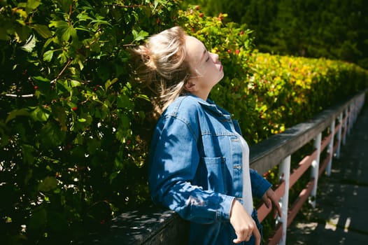 young beautiful woman in jeans clothes outdoors. portrait of a girl with freckles on her face, stylish girl on a sunny summer autumn day.