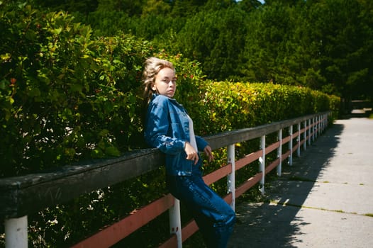young beautiful woman in jeans clothes outdoors. portrait of a girl with freckles on her face, stylish girl on a sunny summer autumn day.