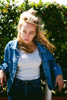 young beautiful woman in jeans clothes outdoors. portrait of a girl with freckles on her face, stylish girl on a sunny summer autumn day.
