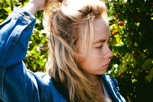 young beautiful woman in jeans clothes outdoors. portrait of a girl with freckles on her face, stylish girl on a sunny summer autumn day.