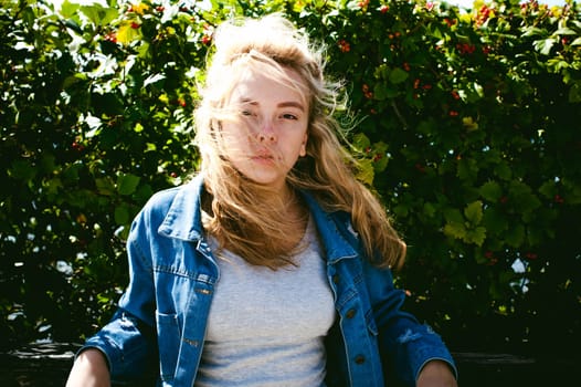 young beautiful woman in jeans clothes outdoors. portrait of a girl with freckles on her face, stylish girl on a sunny summer autumn day.
