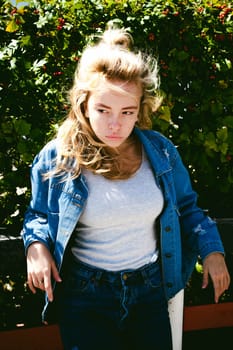 young beautiful woman in jeans clothes outdoors. portrait of a girl with freckles on her face, stylish girl on a sunny summer autumn day.