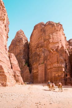 PETRA, JORDAN - APRIL 25, 2016: Arab Jordanian Bedouin man rides a camel in Petra, Jordan.