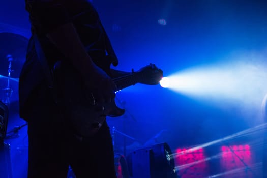 Guitar in the hands of a musician on a rock concert music