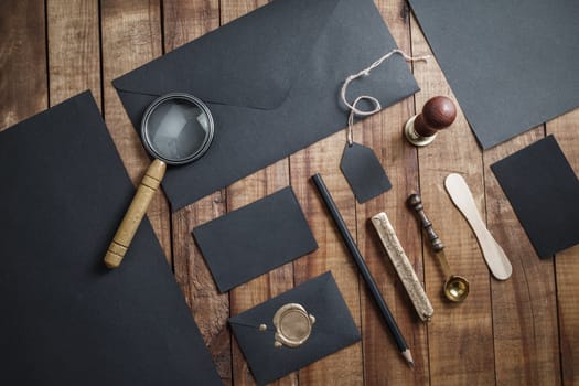 Photo of blank black stationery set on vintage wood background. Corporate identity mockup. Responsive design template.