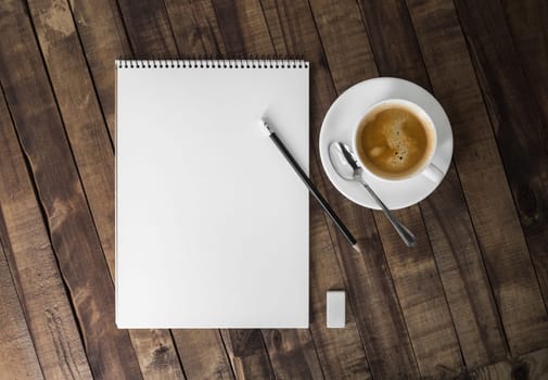 Blank letterhead, clipboard, coffee cup, pencil, eraser and spoon. Stationery template on wooden background. Mock up for placing your design. Flat lay.