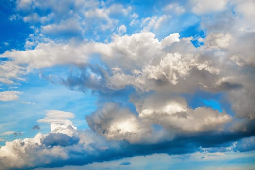Clouds in the blue sky. Sky background with white cumulus clouds on a sunny day.