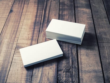 Blank business cards on wood table background. Mockup for branding identity. Studio shot.