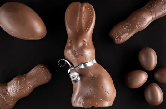 Delicious chocolate Easter bunny and eggs on dark background
