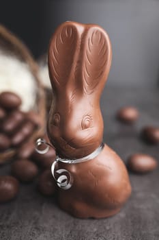 Delicious chocolate Easter bunny and eggs on rustic background