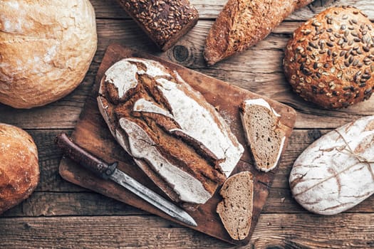 Delicious freshly baked bread on wooden background