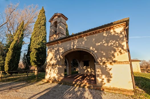Small 13th century rural church with cypresses. Italy Precenicco.
