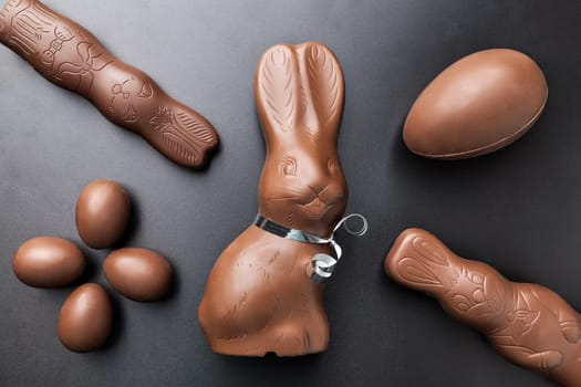 Delicious chocolate Easter bunny and eggs on dark background