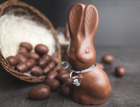 Delicious chocolate Easter bunny and eggs on rustic background