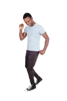 A handsome young African American man in a gray polo shirt and track.pants dancing all by himself, isolated for white background.