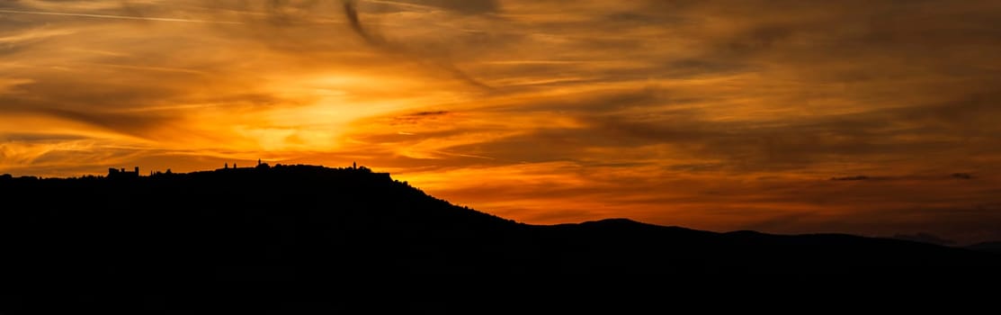 Natural sunsetwith dramatic sky and dark ground. Countryside landscape under colorful sky at sunset.