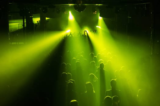 Rock concert crowd people in front of the bright stage lights
