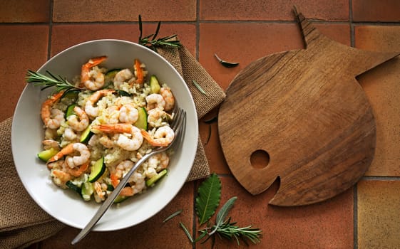 Risotto with shrimp. On a wooden background. Top view. Free space for your text.