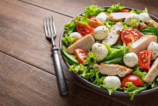 Fresh salad with chicken breast, mozzarella  and tomato. Top view