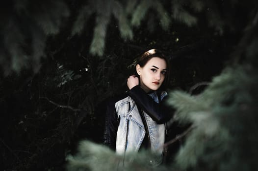 street portrait of a girl student, fashionably dressed in dark clothes, with a black backpack and denim jacket autumn sunny day