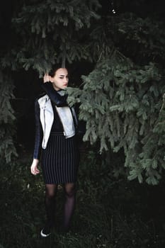 street portrait of a girl student, fashionably dressed in dark clothes, with a black backpack and denim jacket autumn sunny day