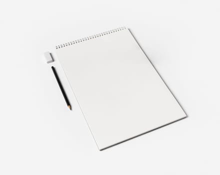 Blank notebook, pen and eraser on white paper background. Notepad and stationery.