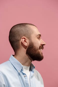 Young casual man smiling. Smile. Emotional man smiling on pink studio background. male profile. Human emotions, facial expression concept. Trendy colors