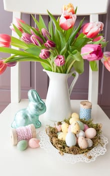 Bouquet of colorful tulips and Easter nest with Easter eggs