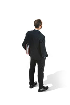 Full body rear or back view of businessman with red folder on white studio background. Serious bearded young man in glasses, suit, red tie standing in office. Business, career, success concept.
