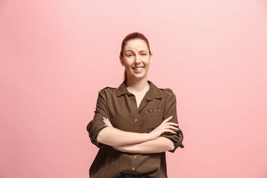 Happy business woman standing and smiling isolated on pink studio background. Beautiful female half-length portrait. Young emotional woman. The human emotions, facial expression concept. Front view.