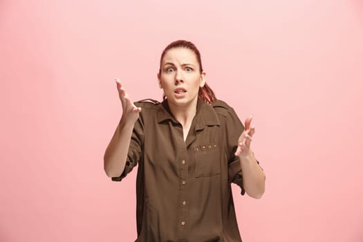 Why is that. Beautiful female half-length portrait isolated on trendy pink studio backgroud. Young emotional surprised, frustrated and bewildered woman. Human emotions, facial expression concept.