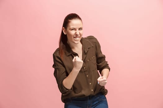 I won. Winning success happy woman celebrating being a winner. Dynamic image of caucasian female model on pink studio background. Victory, delight concept. Human facial emotions concept. Trendy colors