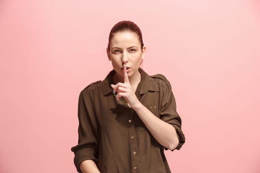 Secret, gossip concept. Young woman whispering a secret behind her hand. Business woman isolated on trendy pink studio background. Young emotional woman. Human emotions, facial expression concept.