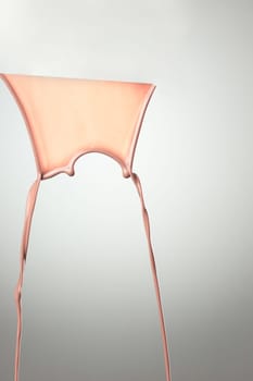 Melted hot chocolate syrup is dripping. Streams with drops isolated on gray background